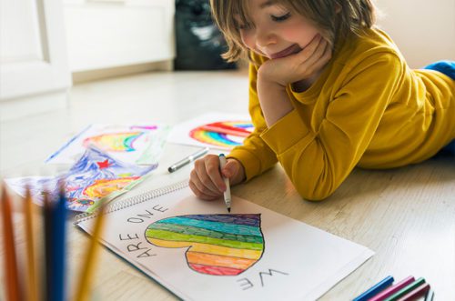 Little kid coloring rainbow heart