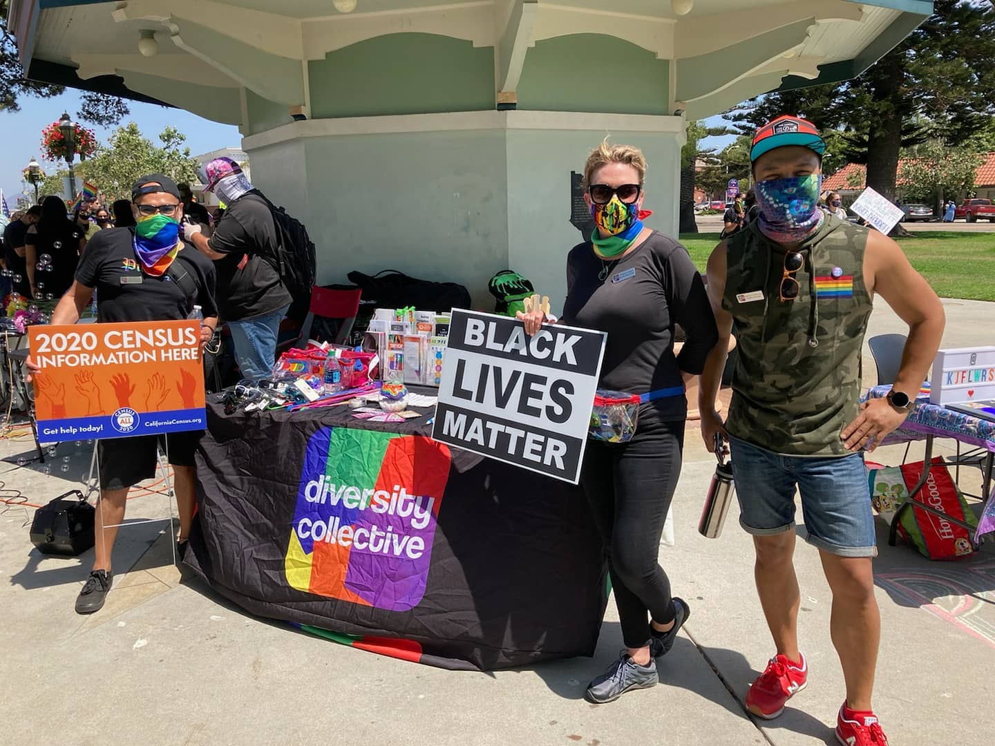 Volunteers at an information booth display materials related to the 2020 census and a "black lives matter" sign, representing the diversity collective.